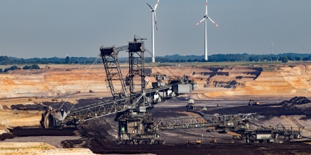 Open pit coal mining with alternative energy wind turbines.